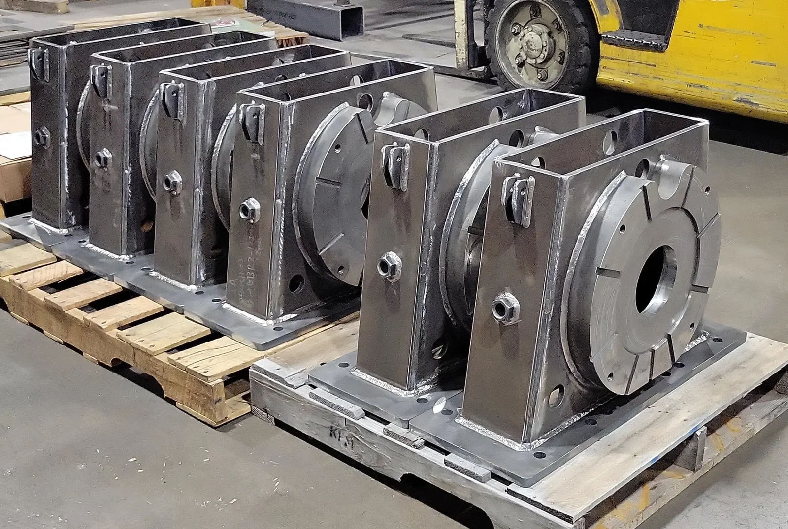 Heavy equipment and mining fabrication at Cutting Edge Fabrication — abrasion-resistant plate housings welded on the Milwaukee shop floor