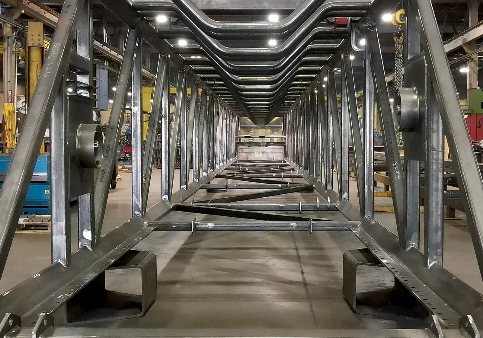 Bulk material handling fabrication at Cutting Edge Fabrication — welded telescopic conveyor rail section on the Milwaukee shop floor